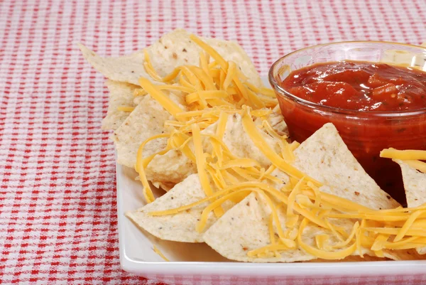 Closeup nachos en kaas zich richten op salsa — Stockfoto