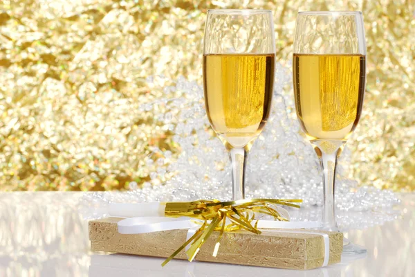 Fluted champagne and a present — Stock Photo, Image