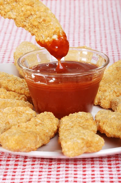 stock image Dipping chicken finger in BBQ sauce