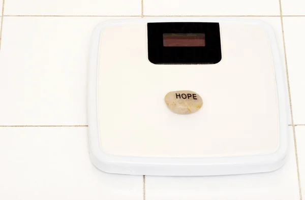 Hope stone on bathroom scale — Stock Photo, Image
