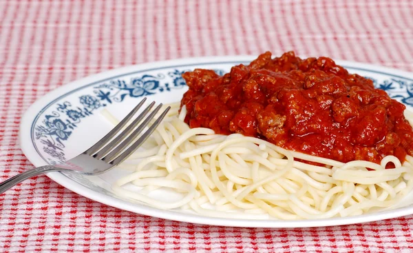 Długi makaron spaghetti z sosem mięsnym i widelcem — Zdjęcie stockowe