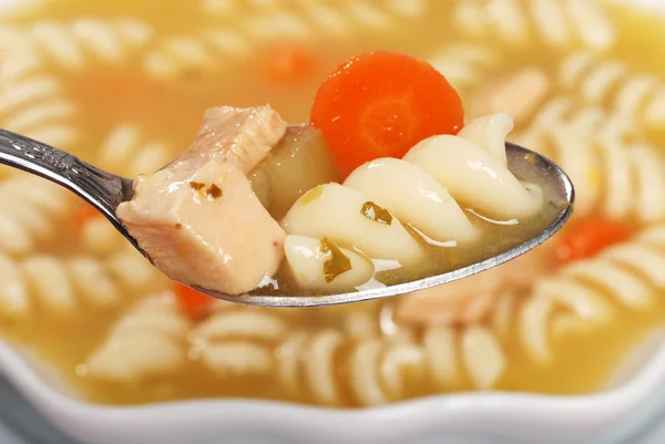 Macro spoonful of chicken pasta soup — Stock Photo, Image
