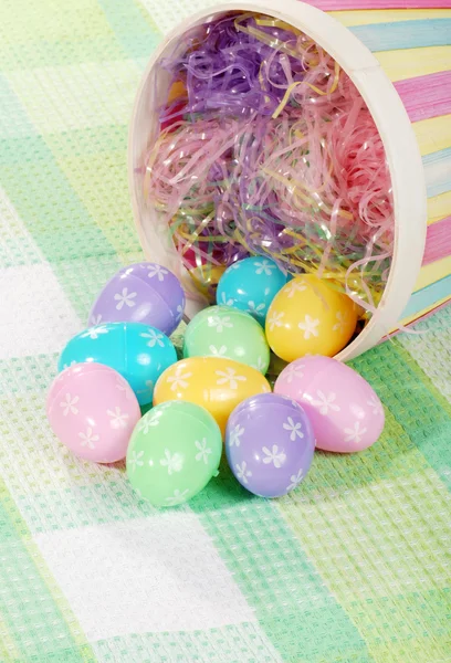 Closeup spilled easter eggs and colorful basket — Stock Photo, Image