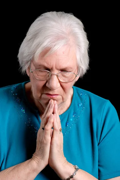Seniorin betet auf schwarz — Stockfoto