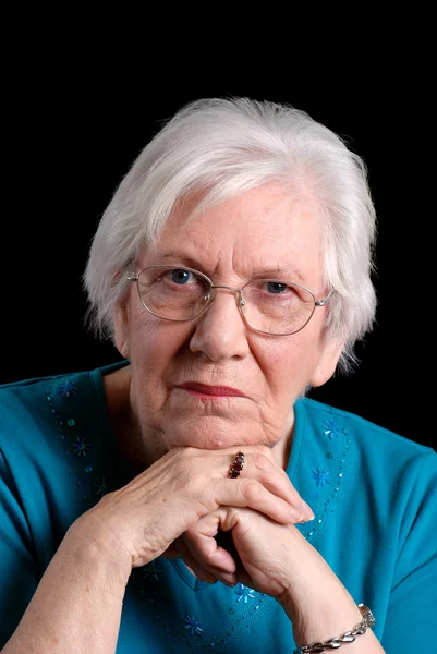 Äldre kvinna stående på svart — Stockfoto