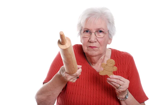 Senior woman protecting gingerbread men cookies — Stock Photo, Image