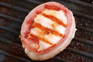 Top view bacon wrapped chicken on grill clipart