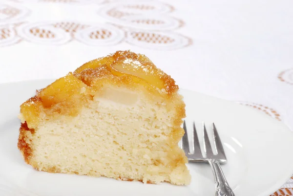 Skiva upp och ner päron kaka med en gaffel — Stockfoto