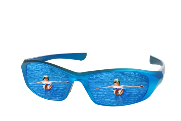 Sunglasses with reflection of child floating — Stock Photo, Image
