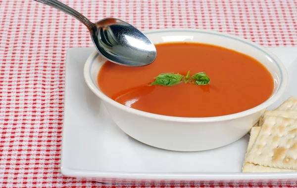 Tomato soup with crackers and basil — Stock Photo, Image