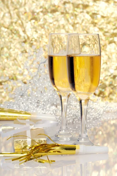 Two glasses champagne with gift and horns Royalty Free Stock Photos