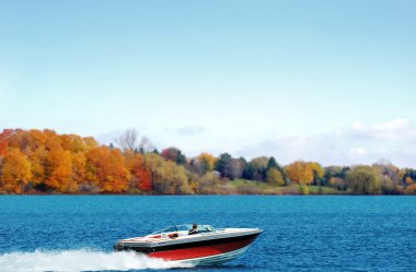 Power boating on an autumn lake clipart