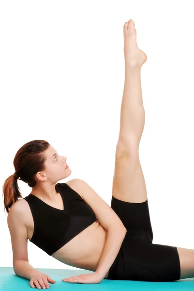 Mujer joven haciendo ejercicio mira su pierna —  Fotos de Stock