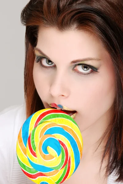 灰色背景上棒棒糖的年轻女人 — 图库照片