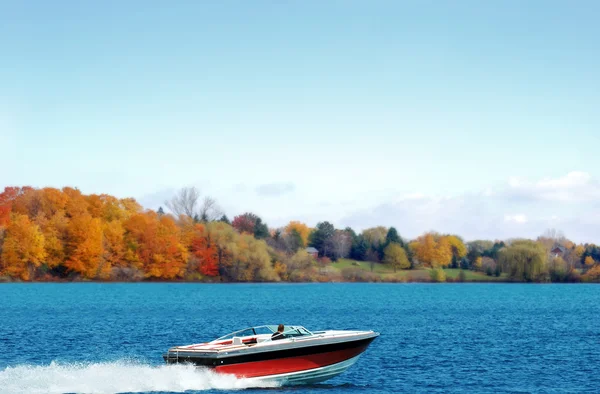 Motorbootfahren auf einem Herbstsee Stockbild