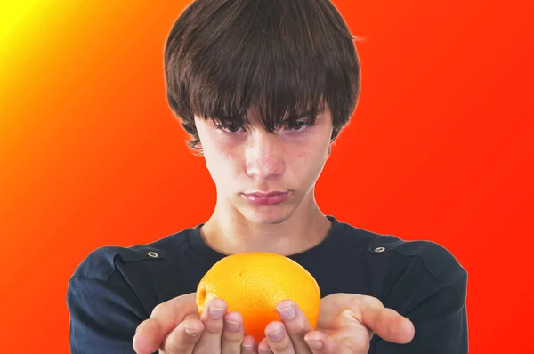 Teenager mit einer Orange lizenzfreie Stockfotos