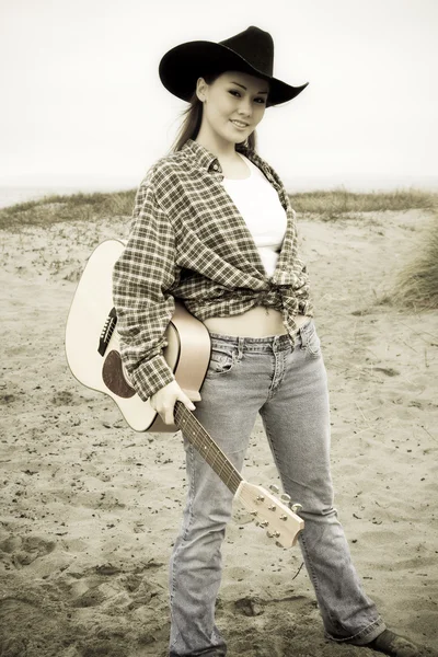 セピア色のトーンでギターを背負った美しい若い女性の肖像画 — ストック写真