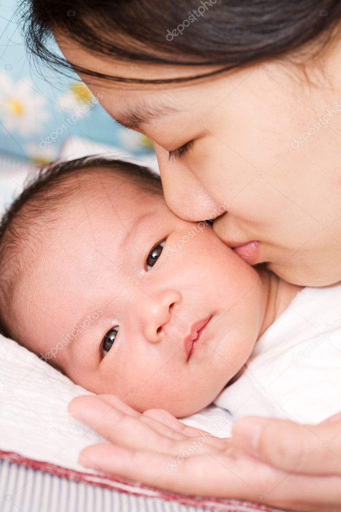 An asian mother kissing her baby boy