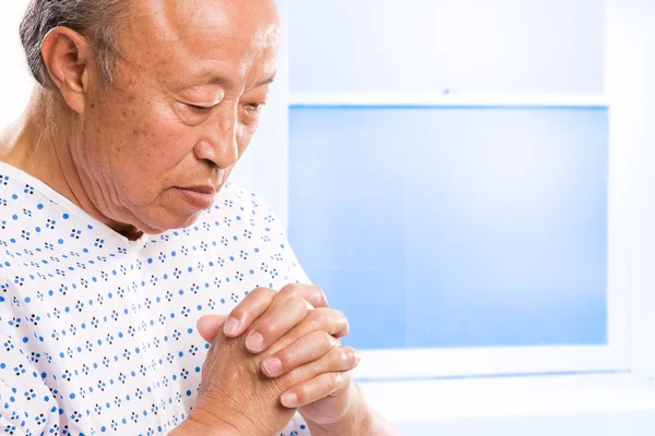 Betender Senior asiatisch im Krankenhaus lizenzfreie Stockfotos