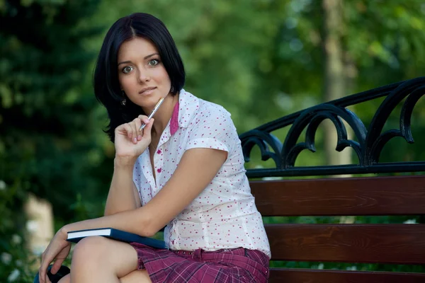 Lány ül a parkban — Stock Fotó