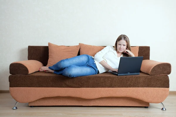 stock image Woman with laptop on the sofa