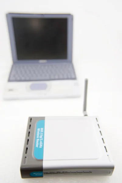 Laptop plateado y router inalámbrico — Foto de Stock