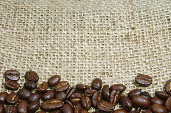 Кофейные зерна на мешковине — стоковое фото