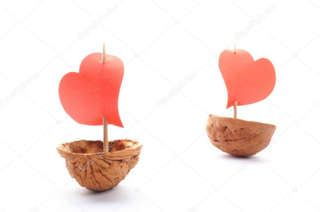 Sailboats made of walnuts with a heart sail isolated on white background