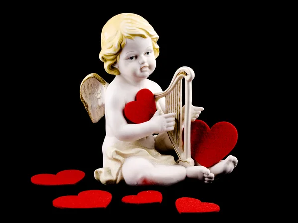 Cupido de cerâmica com coração de feltro em preto — Fotografia de Stock