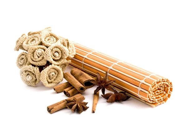 Rolled orange bamboo mat with aromatic spices — Stock Photo, Image