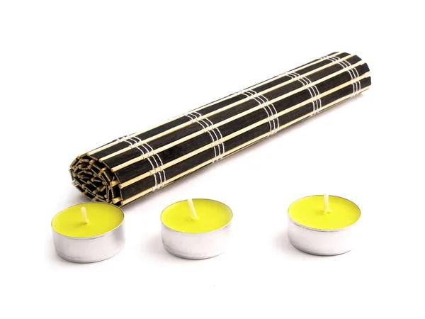 Tappetino di bambù nero e tre candele gialle — Foto Stock