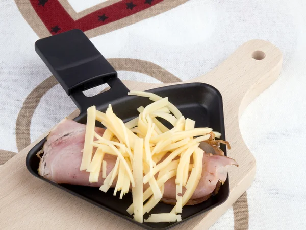 Raclettepfanne mit Käse und Schinken - Party-Essen — Stockfoto