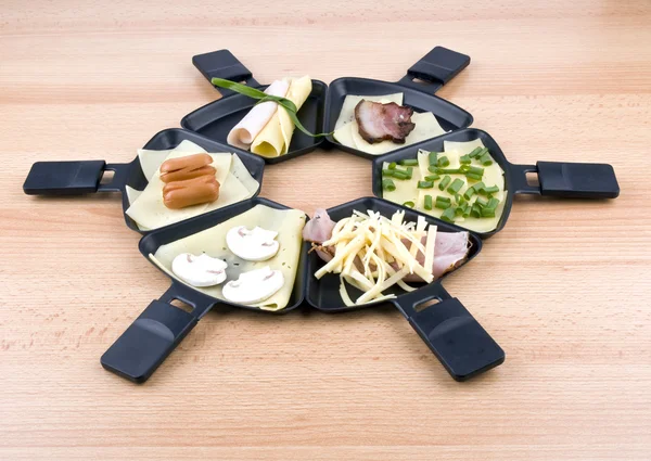 Raclettepfannen mit Essen, ideal zum Feiern — Stockfoto