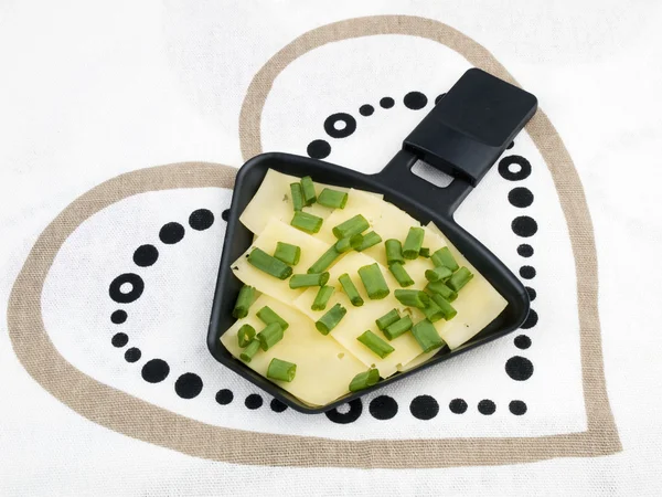 Raclette pan with cheese and spring onion - party food — Stock Photo, Image