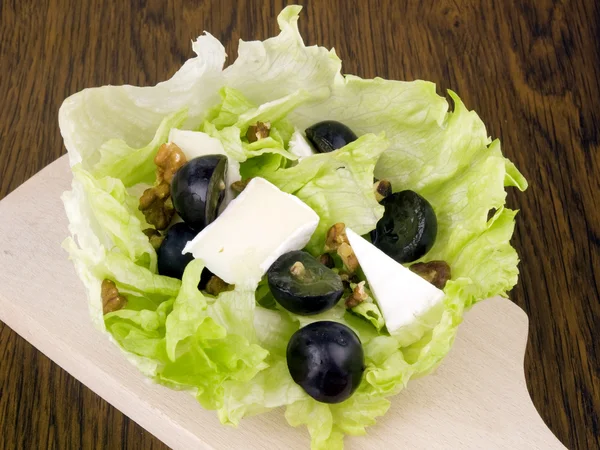 Leckerer Salat mit Camembert-Käse Stockbild