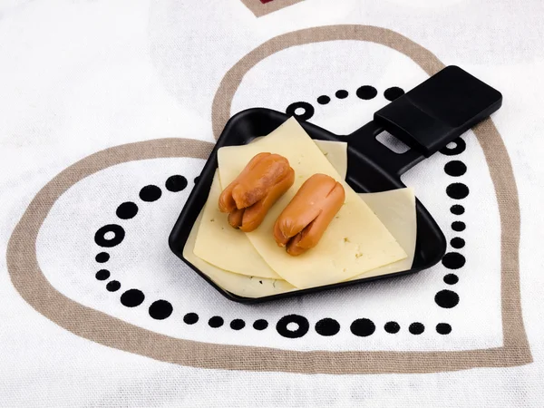 Sartén de raclette con queso y salchichas - comida de fiesta Imágenes de stock libres de derechos