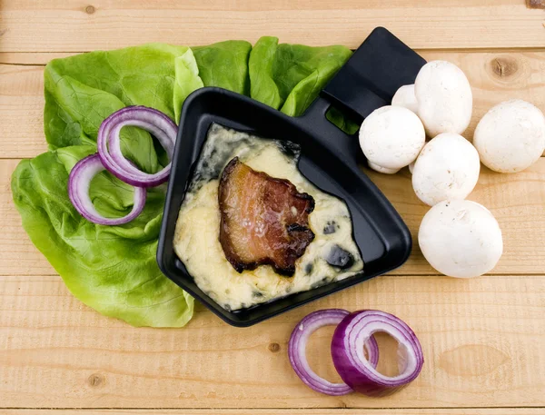 Sartén de raclette con queso y tocino - comida de fiesta —  Fotos de Stock