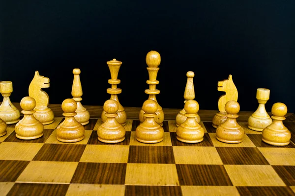 Placa de madeira com figuras de xadrez preto e branco — Fotografia de Stock