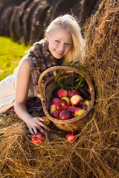 Hermosa rubia sonriente con muchos apple en cesta en hays —  Fotos de Stock