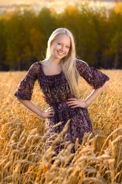 Güzel sarışın kadın elbise güleryüzlü, buğday alanı — Stok fotoğraf