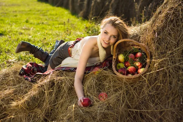 年轻女子在与很多苹果在篮子里的农场 — 图库照片