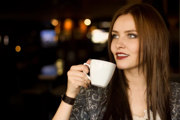 Szép fiatal lány kávét kortyolgatva — Stock Fotó