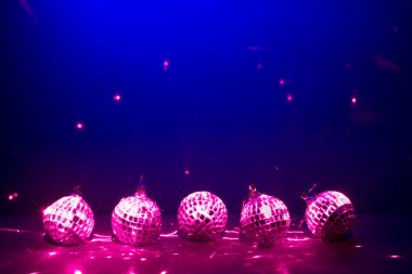 Five purple disco balls reflectoin lights on blue background clipart