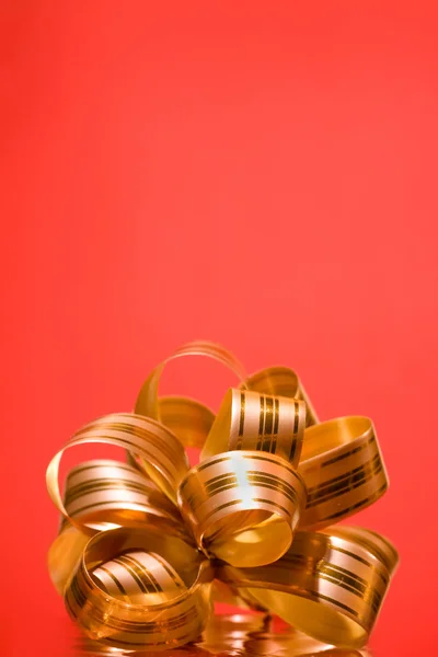 Χρυσή εορταστική τόξο σε κόκκινο φόντο — Φωτογραφία Αρχείου