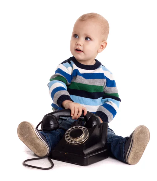 stock image The baby boy with black vintage phone