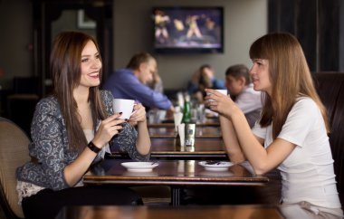 Two girlfriens talking in cafe clipart