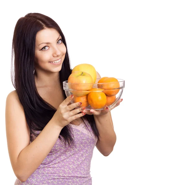 Happy woman holding a dish with fruits on white background — Stock Photo, Image
