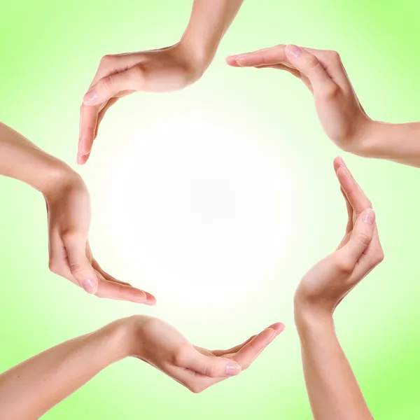 As mãos de mulher feita círculo sobre fundo verde — Fotografia de Stock