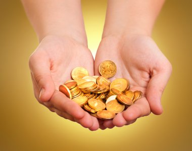 Hands with gold coins on yellow background clipart