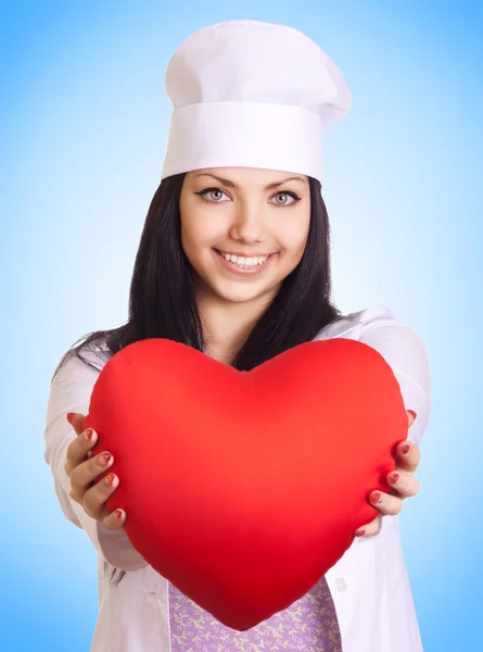 Vrouwelijke arts houden hart op blauwe achtergrond — Stockfoto